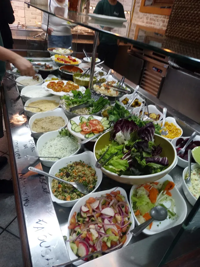 Balcão de saladas variadas com folhas, legumes e molhos