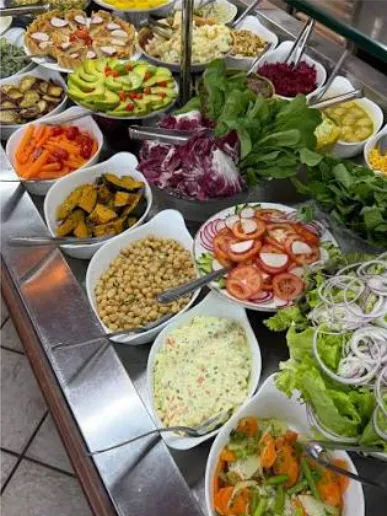 Balcão de saladas com tigelas coloridas e talheres
